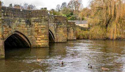 Fototapeta premium Ancient stone bridge over the River Wye in the Derbyshire town of Bakewell