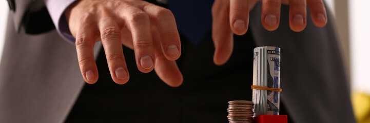 Male arm in suit reach for money closeup