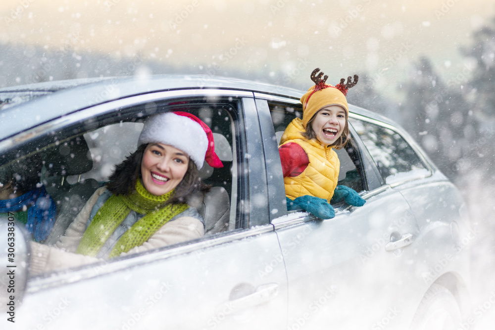 Wall mural mother, child and car on snowy winter nature