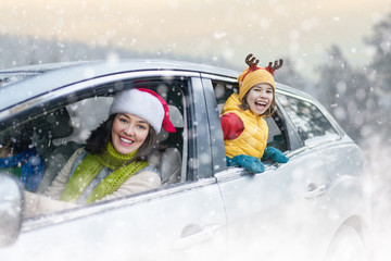 Mother, child and car on snowy winter nature