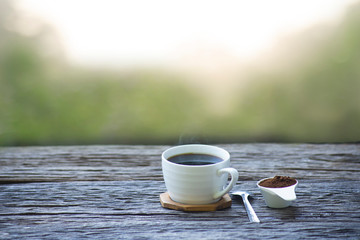 Coffee cups placed on antique wooden tables in vintage style. With a green bokeh background 