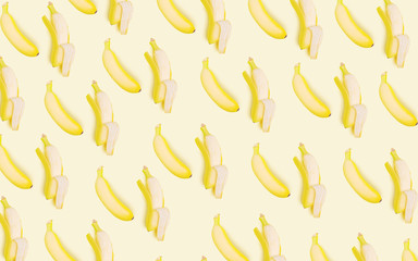 Whole and open bananas on a light background. Vegetarian concept. Creative drawing, minimalism, top view, flat lay. Tasty and healthy food.