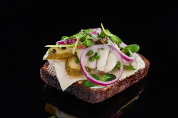 close up of herring fish on tasty danish smorrebrod sandwich on black