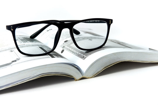 Eyeglasses on book isolated white background - image