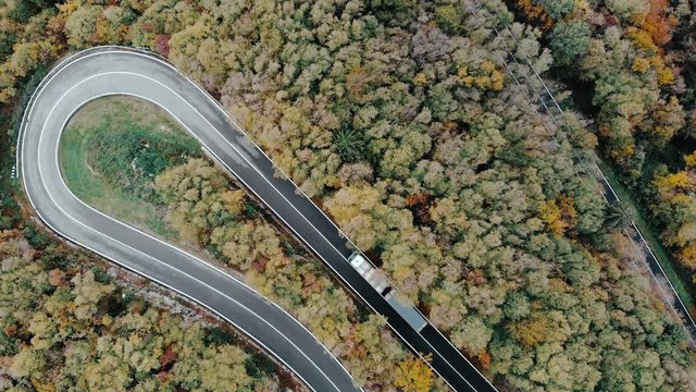 Winding road through a forest, truck taking a sharp turn