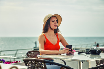 Portrait of a young happy woman in a straw hat on vacation