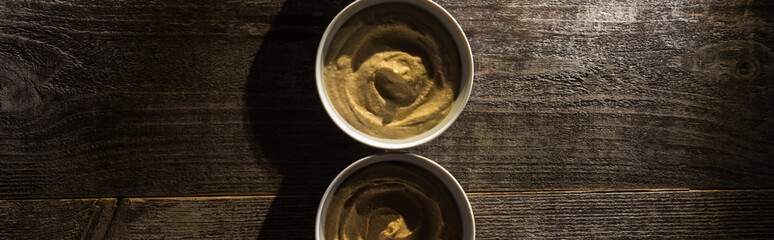top view of delicious assorted hummus on wooden rustic table, panoramic shot