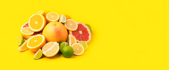 Citrus fruits (orange, lemon, grapefruit, lime) on yellow background. Summer concept. Set of tropical fruits