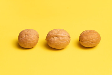 Delicious walnuts on bright yellow background.