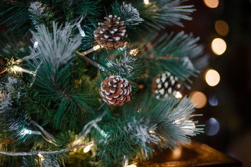 Elements of Christmas decorations at home close-up. Christmas interior lights garlands, wooden toys, gifts under the tree