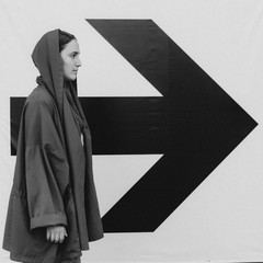 Black and white shot of Young woman in red staying near arrow sign. Success concept