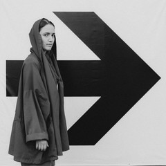 Black and white shot of Young woman in red staying near arrow sign. Success concept