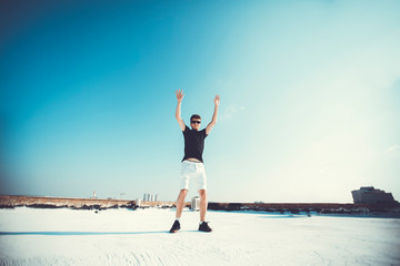 Obraz premium Young attractive man jumping in the air on the roof of a residential building