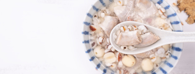 Tasty Four Tonics Herb Flavor Soup, Taiwanese traditional food with herbs, pork intestines on white wooden table, close up, flat lay, top view.