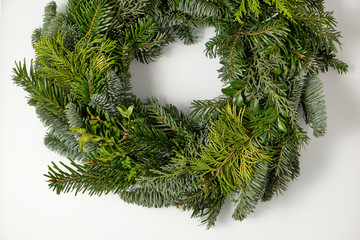 Closeup of a bare fresh and green Advent wreath without christmas decoration lying isolated on a white glass plate © franconiaphoto