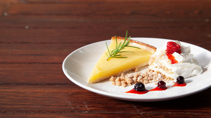 Fresh tasty lemon tart with crumble and whipped cream