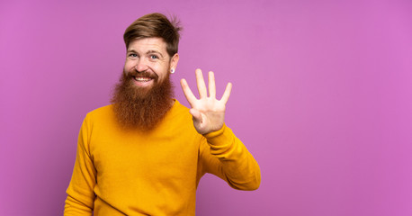 Redhead man with long beard over isolated purple background happy and counting four with fingers