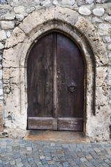 Fototapeta na wymiar old wooden door of church in hall in tyrol