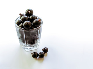 A glass filled with blackcurrant berries. The concept of natural juice, organic nutrition, vitamin breakfast