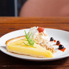 Fresh tasty lemon tart with crumble and whipped cream