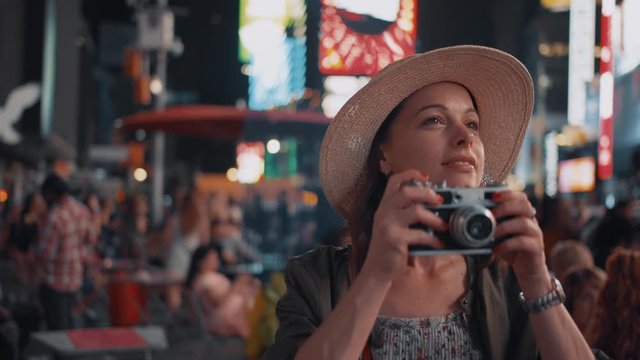 Attractive photographer with a camera in Times Square at night