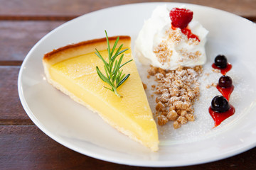Fresh tasty lemon tart with crumble and whipped cream