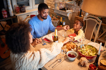  family praying at the christmas table