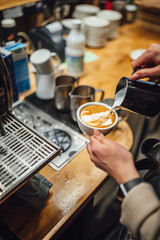 Fototapeta na wymiar Barista makings coffee in coffee shop, cappuccino making