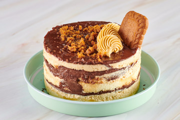 Cake with chocolate cream and biscuit in a plate