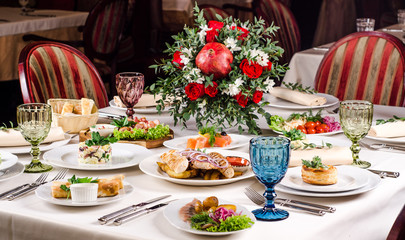 Empty glasses set in restaurant. Served for holiday banquet restaurant table with dishes, snack, salads, cutlery, wine and water glasses. European food