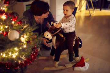 baby and mom enjoy a beautiful decorated Christmas tree
