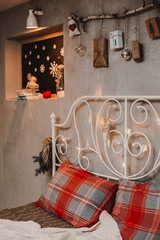 Christmas bedroom decoration in loft style, concrete gray and stick with gifts hanging on the wall.