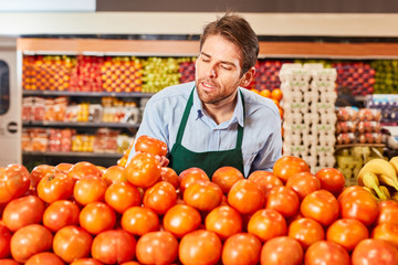 Verkäufer sortiert Tomaten in der Gemüseabteilung