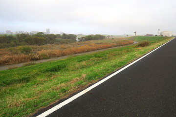 朝靄の中のサイクリング道路と江戸川河川敷風景