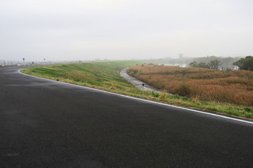 朝靄の中のサイクリング道路と江戸川河川敷風景