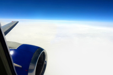 View from the window of a flying airplane. Flying above the clouds, airplane wing, turbine