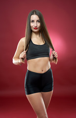 Fitness model doing workout on red background