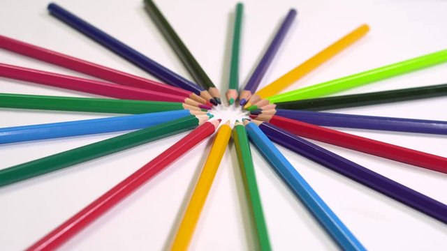 rotating revolving shot of wooden color pencils in circle shape floral shape with nibs in focus on white background 4K