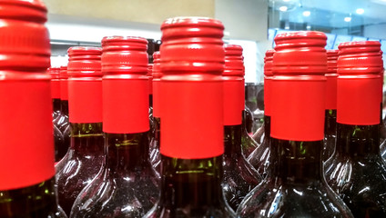 Rows of vine bottles with red stoppers on the shop window