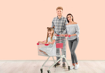 Family with shopping cart near color wall