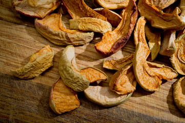 Dried sliced apples, healthy, closeup shot on a wooden surface.