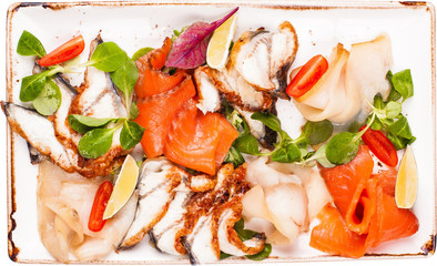 Plate with fresh salmon, eel and tomatos isolated on white.