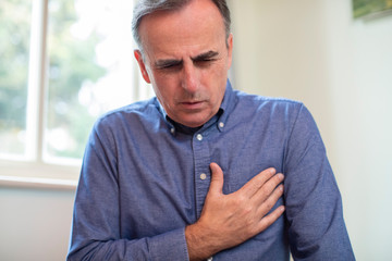 Mature Man Suffering Heart Attack And Chest Pains At Home