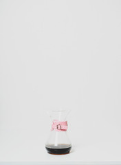 Glass coffee jug with pink holder isolated