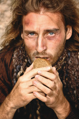 Portrait of poor homeless man with piece of bread outdoors