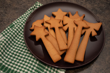 Do it yourself: Gingerbread cookies tutorial. Step by step recipe. Step 26 . Homemade gingerbread cookies on a plate with green check tea towel