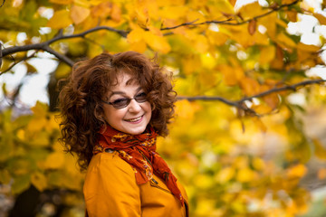 Seasonal portrait of a mature woman outdoor in vibrant forest