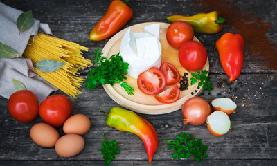 .Italian food ingredients - pasta, vegetables, eggs on a wooden background