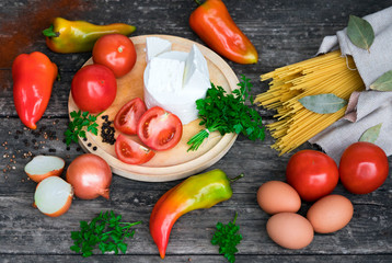cheese, vegetables, eggs, pasta on a wooden background