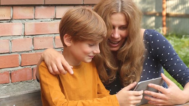 Mom and son look at the tablet screen